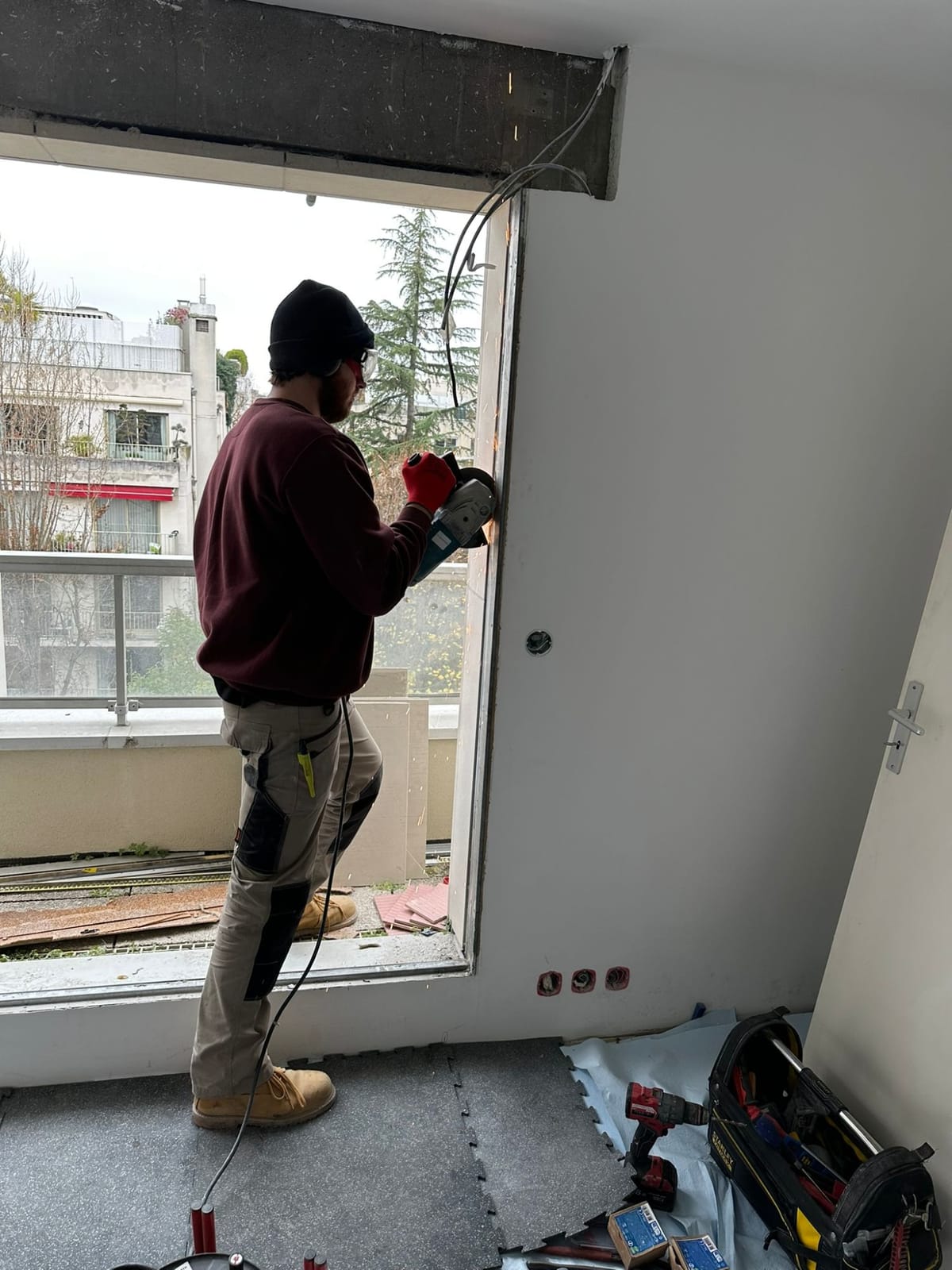 Victor découpe le cadre d’une ouverture lors d’un chantier de rénovation